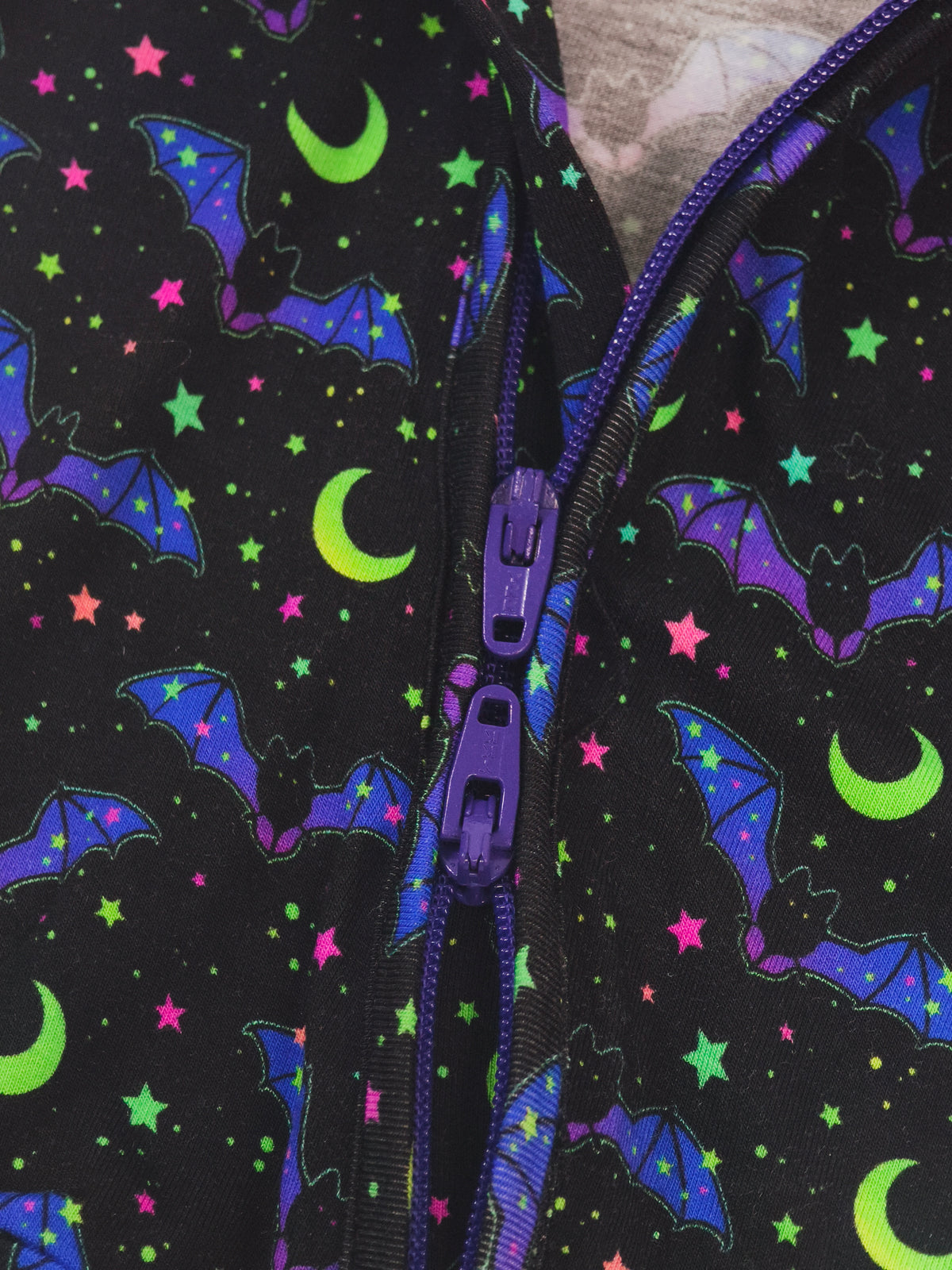 Cosmic Bats Bamboo Zipper Sleeper showing colorful bat and star pattern with dual zippers.