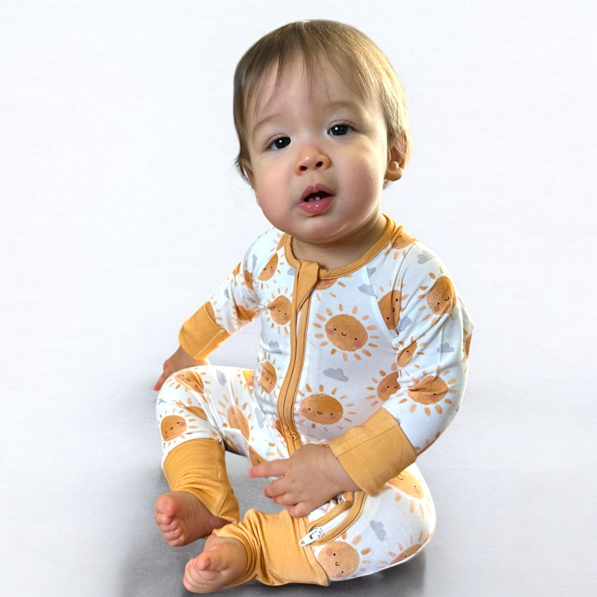 Boho Sun Zipper Sleeper on a baby showcasing a cute sun print and dual zipper design for comfort.