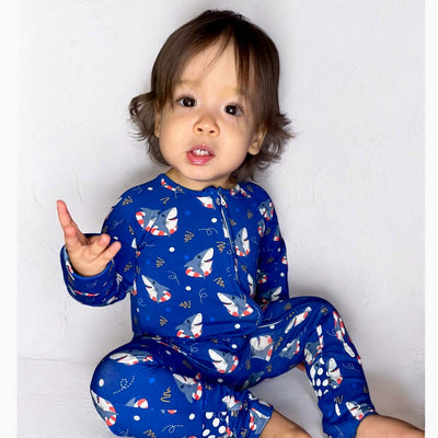 Toddler wearing Shark Floaties Blue Bamboo Zipper Sleeper, showcasing playful shark pattern and vibrant blue color.