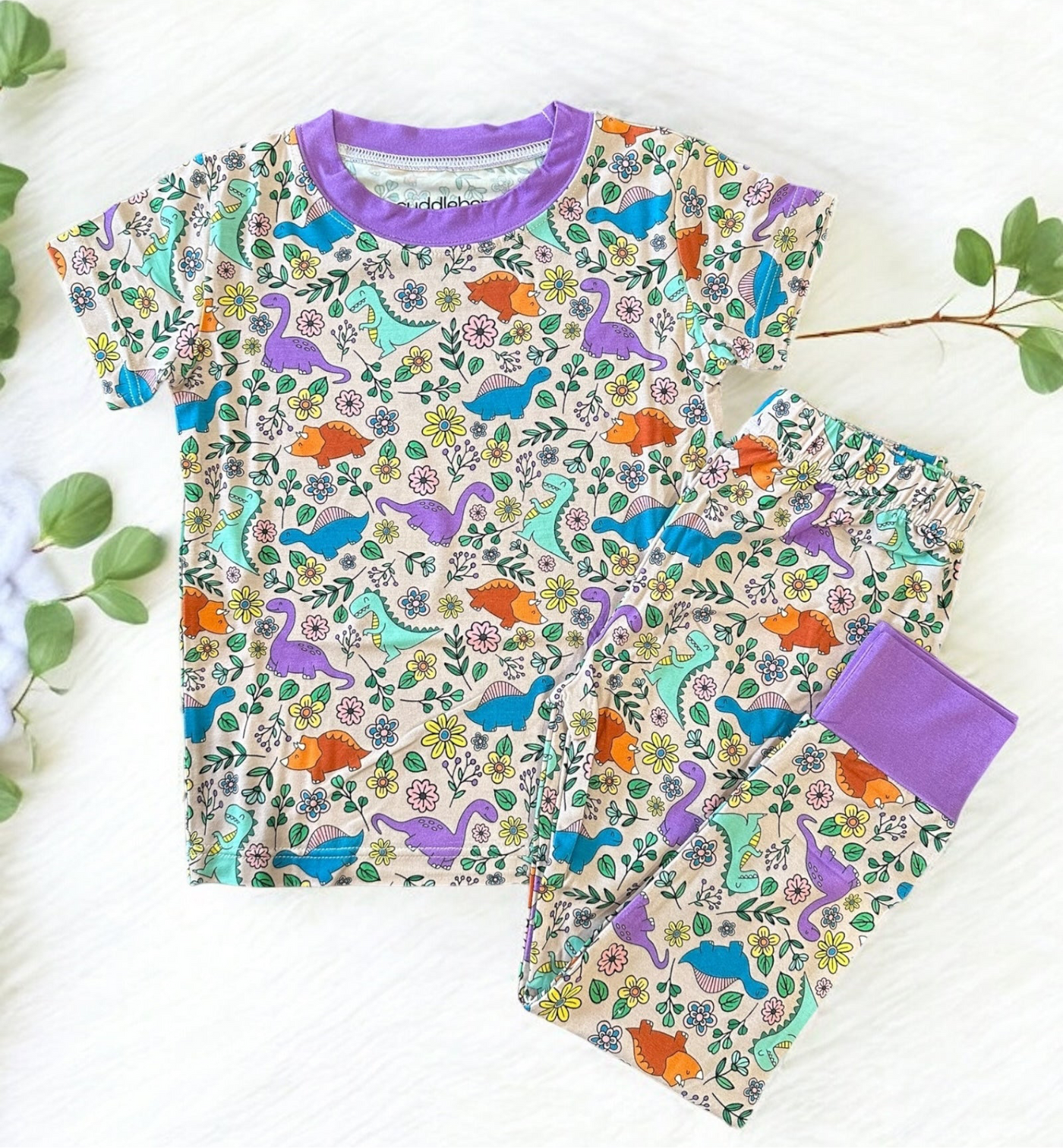 Dinosaur floral short sleeve two-piece pajamas for kids featuring colorful dinosaurs and flowers.