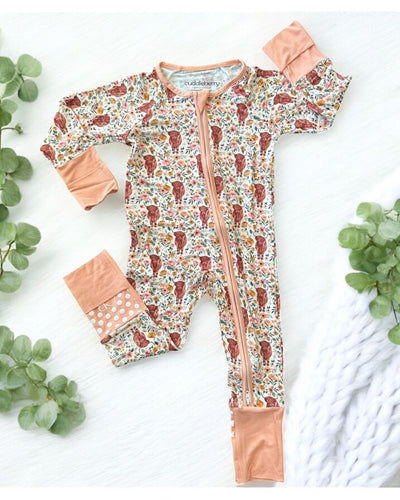 Highland Cow bamboo zipper sleeper for babies with floral pattern and peach accents, designed for comfort and ease.